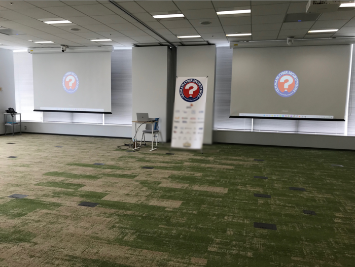大型プロジェクターがあるイベント会場。イベント開始時間までスポンサーCMが流れていました。